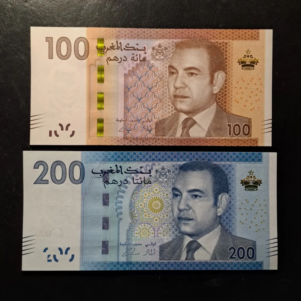 Billets marocains de 100 et 200 dirhams de la série 2012, côté portrait, sur fond noir