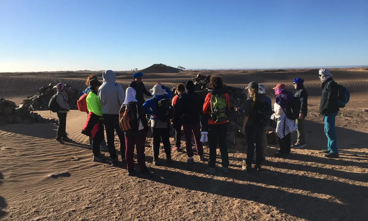 Guía explicando la ruta a un grupo de senderistas antes de empezar a caminar por el desierto