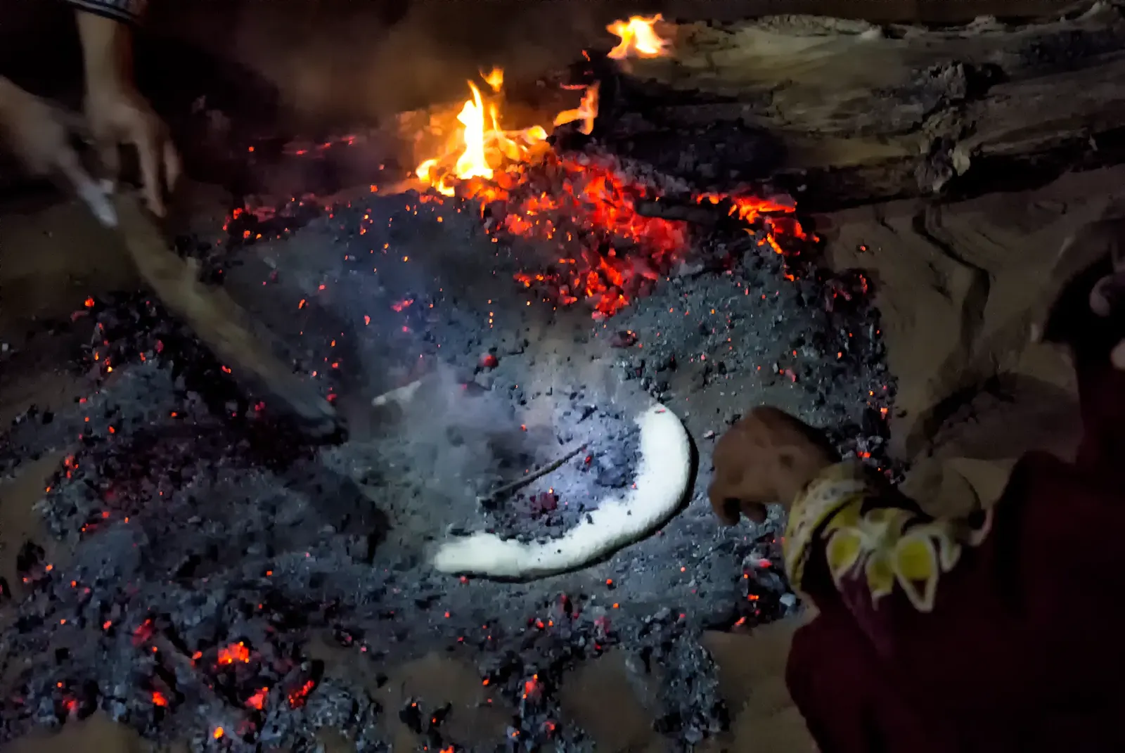 Pâte de la tagoula posée sur les braises d'un feu de bivouac dans le désert marocain