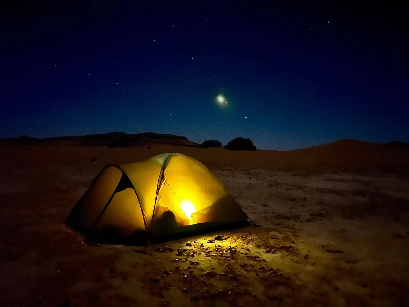 Tienda iluminada bajo un cielo estrellado en el desierto de Marruecos