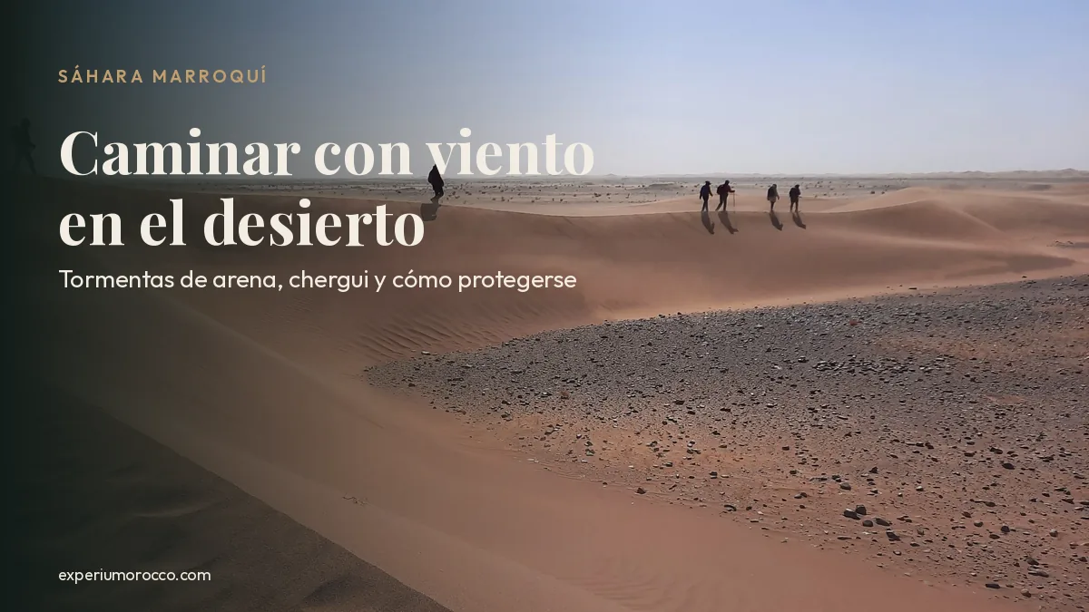 Senderistas en la cresta de una duna mientras el viento levanta la arena en el desierto del Sáhara, Marruecos